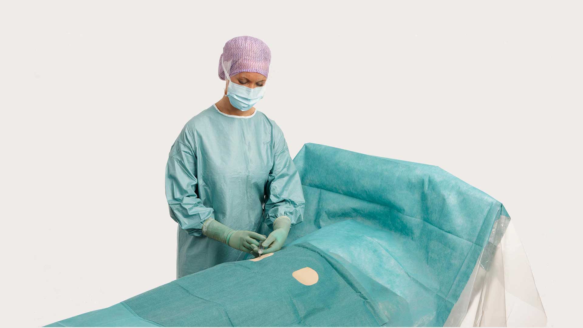 chirurgas, naudojantis „BARRIER“ angiografijos apklotą operacijai