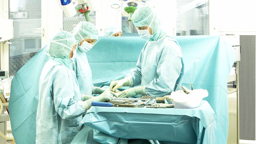 gydytojai operacinėje, ruošdami chirurginius įrankius